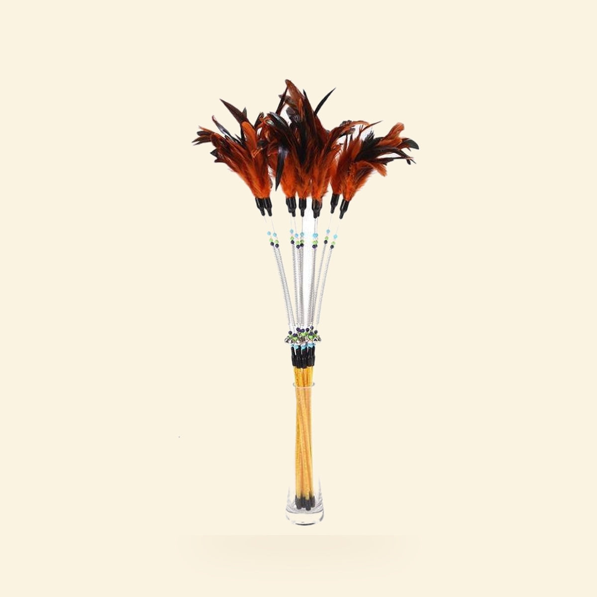 Feather and bell cat wand with a springy tip on a cream background