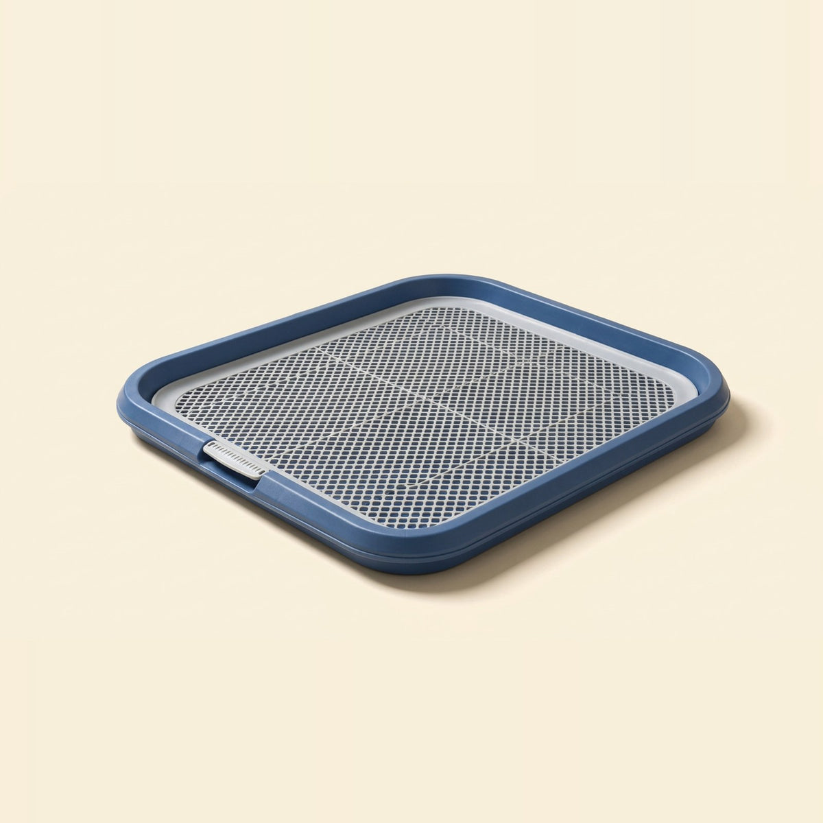 Navy blue leak-proof dog potty tray with a grid top on a cream background